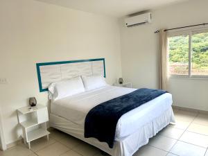 a white bedroom with a large bed and a window at Luxury Simpson bay condo in Koolbaai