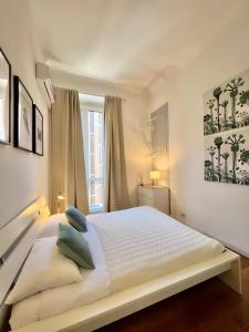 - une chambre blanche avec un grand lit blanc et des oreillers bleus dans l'établissement ComeCasa 2 bedrooms Apartment in via Curtatone, à Milan