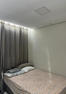 a bed in a room with a curtain at Próx Aeroporto Confins e Belo-Horizonte, Cidade do Galo, Mega Space in Vespasiano