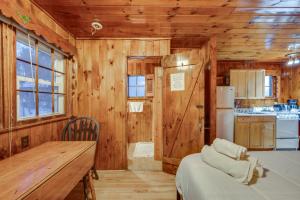 a wooden room with a table and a kitchen at Cozy Laconia Studio with Pool Access - 2 Mi to Lake! in Laconia