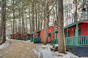 a row of red and green houses in the woods at Cozy Laconia Studio with Pool Access - 2 Mi to Lake! in Laconia