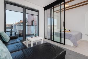 een woonkamer met een bank en een slaapkamer bij Browar Gdański One Bedroom Apartments with Free Parking by Renters in Gdańsk