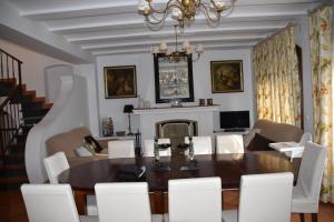 Casa Rural Almonaster la Real, Marques de Robledal في ألموناستير لا ريال: غرفة طعام مع طاولة خشبية وكراسي بيضاء