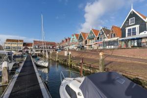 a boat is docked at a marina with houses at Cosy house in the centre city of Volendam in Volendam