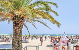 a palm tree on a beach with a crowd of people at Cozy Home In Pescara With Wifi in Pescara