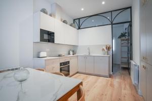 kuchnia z białymi szafkami i dużym oknem w obiekcie Amazing apartment-3Bedrooms 3Bathrooms-Lavapiés w Madrycie