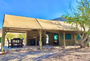 a house with a tent in the desert at Khowarib Lodge in Khowarib