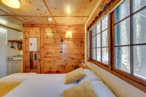 a log cabin bedroom with a bed and windows at Quiet Laconia Studio, Near Mill Falls Marketplace! in Laconia