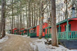 a row of red and green houses in the woods at Quiet Laconia Studio, Near Mill Falls Marketplace! in Laconia