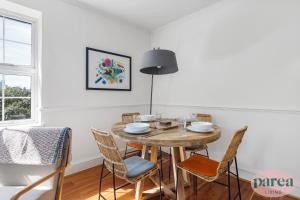 a dining room with a wooden table and chairs at Parea Living - Stylish Islington 1-Bed Flat, 6min Walk to Tube in London