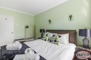 a bedroom with a large bed with white sheets and pillows at Parea Living - Stylish Islington 1-Bed Flat, 6min Walk to Tube in London