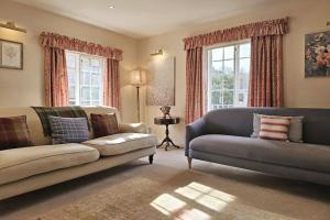 a living room with two couches and a window at Spacious Cottage in the Centre of Burford, Cotswolds in Burford