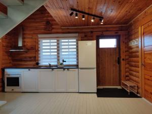 una cucina con mobili bianchi e un frigorifero di Tapa Cottage next to disc golf. a Tapa
