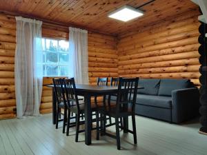 a dining room with a table and chairs and a couch at Tapa Cottage next to disc golf. in Tapa