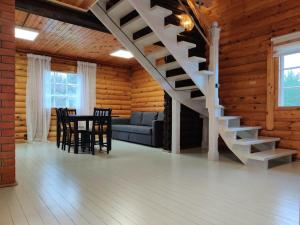 ein Wohnzimmer mit einer Treppe, einem Tisch und Stühlen in der Unterkunft Tapa Cottage next to disc golf. in Tapa