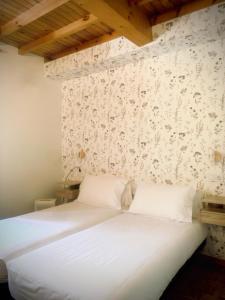 サンティアゴ・デ・コンポステーラにあるHostal As Margaritasの白い壁のベッド1台