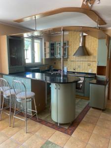 a kitchen with a large island with chairs in it at Apartament „Na wydmie” in Ustka