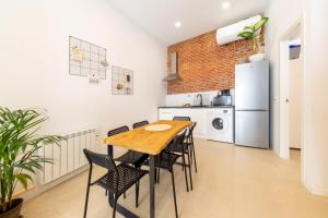 馬德里的住宿－2 bedrooms 1 bathroom furnished - Lavapies - Modern Cozy - MintyStay，厨房配有桌椅和冰箱。