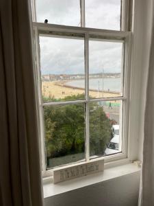 an open window with a view of a beach at Seascape guest house in Melcombe Regis