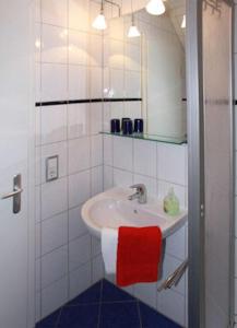 W łazience znajduje się umywalka z czerwonym ręcznikiem. w obiekcie Seeblick Wohnung 121 w Koserowie