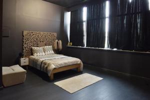 1 dormitorio con 1 cama, 1 silla y ventanas en Havre de paix en Evry-Courcouronnes