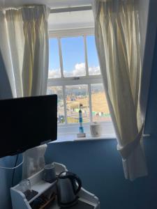 a room with a window and a monitor and a desk at Seascape guest house in Melcombe Regis
