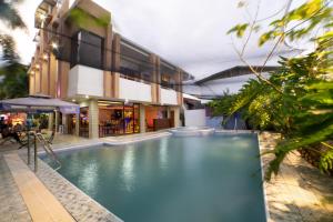 une grande piscine en face d'un bâtiment dans l'établissement Casañas Suites, à Puerto Princesa