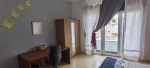 Cette chambre dispose d'un bureau et d'une grande fenêtre. dans l'établissement Apartamento completo ultra central, à Bucarest