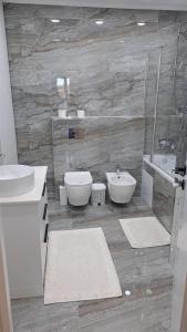 ein Badezimmer mit einem Waschbecken, einem WC und einer Badewanne in der Unterkunft Airport.24/24 in Chişinău