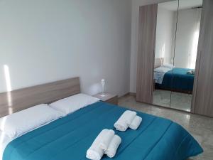 a bedroom with a blue bed and a mirror at Casa della Nonna in Bitonto