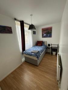 a bedroom with a bed and a table in it at Hatton Homes - Tottenham Hotspurs Stadium in London