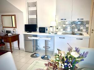 una cocina con fregadero y una mesa con un jarrón de flores en CasAzzurra, en Ortona