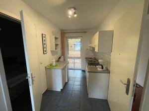 a small kitchen with white cabinets and a tile floor at Seeblick Wohnung 202 EG mit Ostseeblick in Ostseebad Koserow