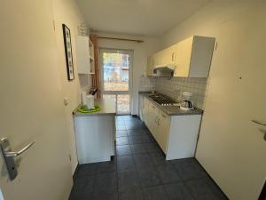 a small kitchen with white appliances and a window at Seeblick Wohnung 202 EG mit Ostseeblick in Ostseebad Koserow