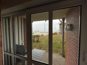 een glazen schuifdeur met uitzicht op een tuin bij Seeblick Wohnung 202 EG mit Ostseeblick in Ostseebad Koserow