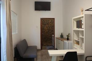 - un salon avec une chaise, un bureau et une porte dans l'établissement Bezalel Wine & Brandy Estate, à Kanoneiland