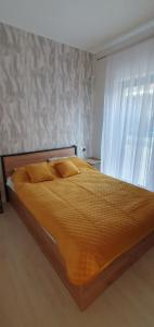 um quarto com uma cama grande com lençóis amarelos em Apartamenty w Sercu Sosnówki em Sosnówka