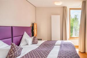 a bedroom with a large bed with a purple headboard at Ferienwohnung Wellvital in Bad Endorf