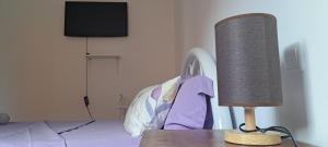 a lamp sitting on a table next to a bed at Homestay Maio Apartment in Vila do Maio