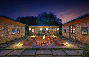 a patio with a fire pit in a building at night at Bagh Serai - Rustic Cottage with Private Pool in Sawāi Mādhopur