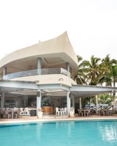 - un bâtiment avec une piscine à côté d'un complexe dans l'établissement Hotel el barco, à Azua de Compostela