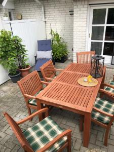 einen Holztisch und Stühle auf einer Terrasse in der Unterkunft Fehmarn-OstseeferienHoeben Huus  216 in Fehmarn