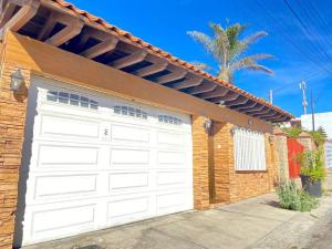 una puerta de garaje blanca en una casa de ladrillo en Zebra Studio, en Tijuana