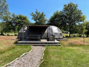 una tienda en un campo con césped y árboles en Camping de Reeënwissel, en Hoogersmilde