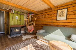 una camera con divano e camino in una baita di tronchi di Elupuu forest cabin with sauna a Nooska