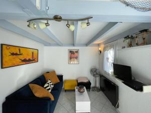 uma sala de estar com um sofá azul e uma televisão em Villa Capbreton, 3 pièces, 4 personnes - FR-1-413-139 em Capbreton