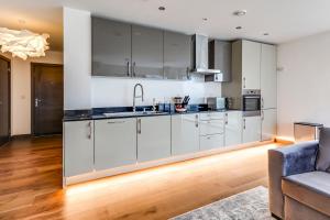 a kitchen with white cabinets and stainless steel appliances at Stylish flat in Peterborough in Peterborough +4 photos