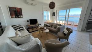 Precioso piso con vistas espectaculares del mar في روساس: غرفة معيشة مطلة على المحيط