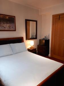 a bedroom with a large white bed and a mirror at Number Five in Brighton & Hove