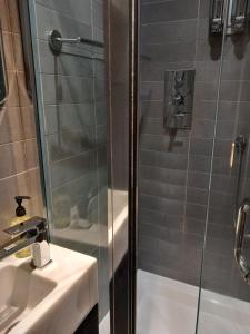 a shower with a glass door next to a sink at Number Five in Brighton & Hove